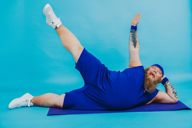 Hombre gordo divertido haciendo algunos ejercicios deportivos