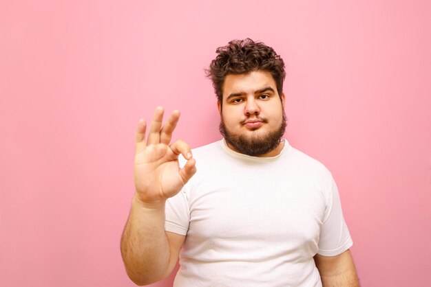 Hombre gordo molesto con barba mostrando los pulgares hacia arriba gesto OK aislado