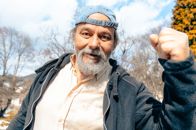 Un hombre con una gorra azul levanta el puño.