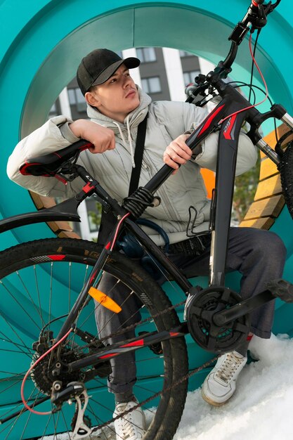 Un hombre con una gorra y una chaqueta cálida disfruta de un paseo en bicicleta por la ciudad