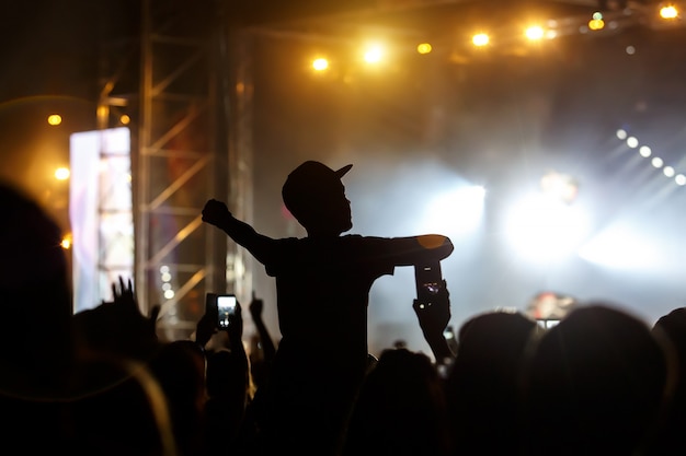 El hombre de la gorra disfruta del concierto, silueta negra