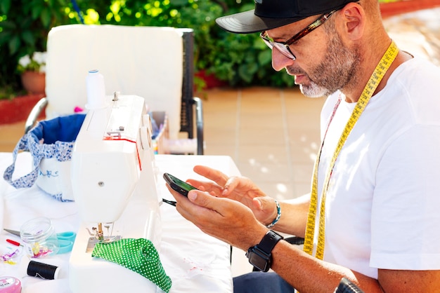 Hombre con gorro de coser máscaras faciales en su casa