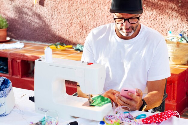 Hombre con gorro de coser máscaras faciales en su casa