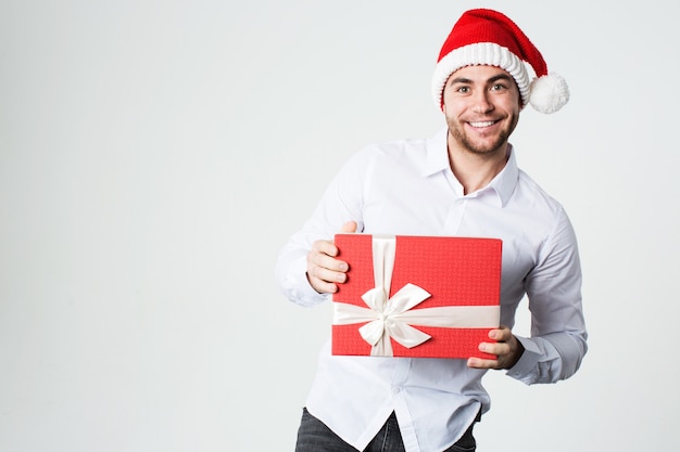 Hombre con gorro de Papá Noel con caja de regalo