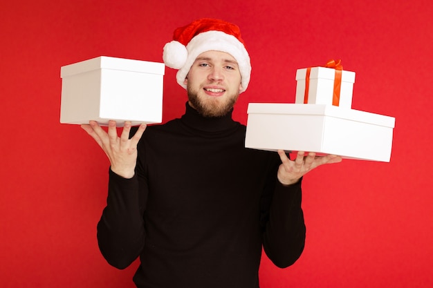 Un hombre con un gorro de Papá Noel elige entre regalos
