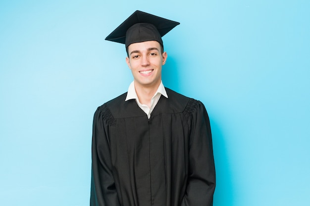 Hombre graduado caucásico joven feliz, sonriente y alegre.