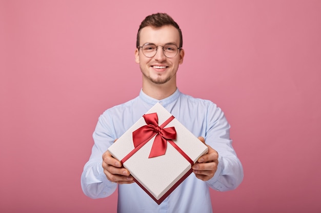 hombre gratamente sorprendido en camisa azul con gafas tiene regalo en caja