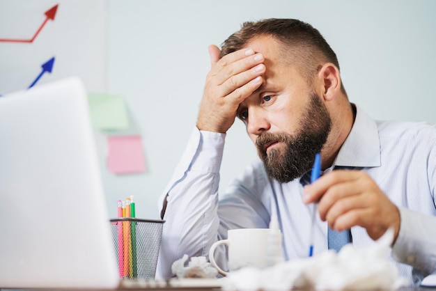 Hombre con gripe trabajando en la oficina