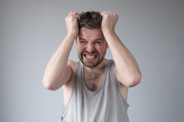 Foto hombre gritando de pánico aterrorizado o furioso con las manos al lado de la cabeza