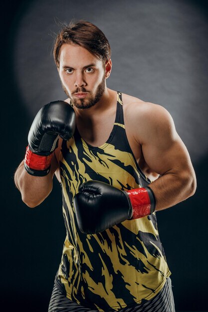 Un hombre con guantes de boxeo Un hombre Boxeando sobre un fondo negro El concepto de un estilo de vida saludable