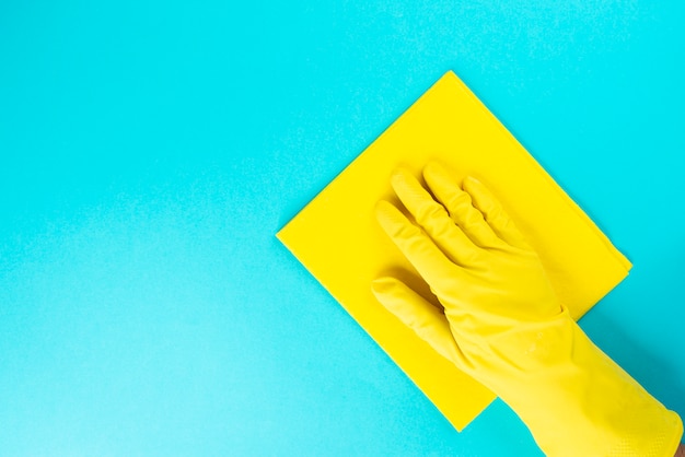 Hombre con guantes de goma protectora con paño de microfibra para limpiar, limpiar el concepto de superficie.