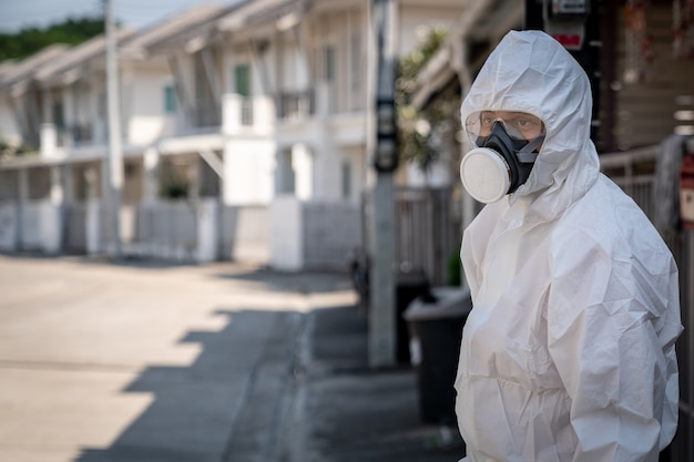 Hombre con guantes con traje de protección química biohazard y máscara con cara infeliz.