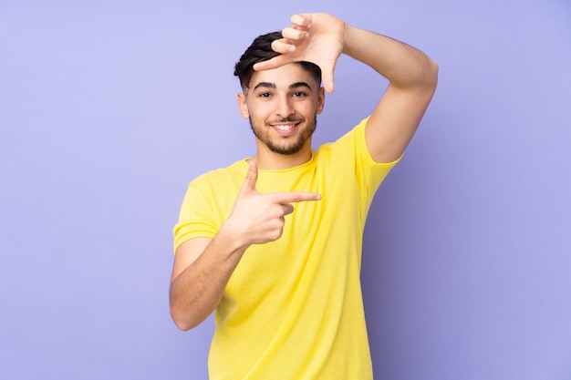 Hombre guapo árabe sobre la cara de enfoque de pared aislada. Símbolo de encuadre