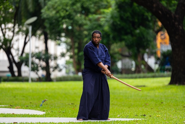 Foto hombre guapo artista marcial negro con traje de artes marciales de kendo