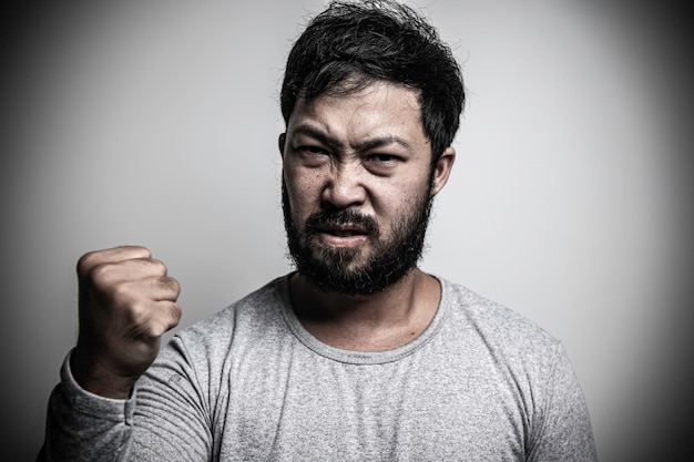 Hombre guapo asiático enojado sobre fondo blanco. Retrato del concepto masculino de estrés joven.