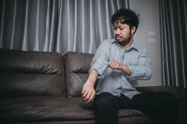 Hombre guapo asiático estrés por sobrecarga de trabajo Hombre cansado vuelve a casa después de mucho trabajo de la empresa Riesgo de depresión