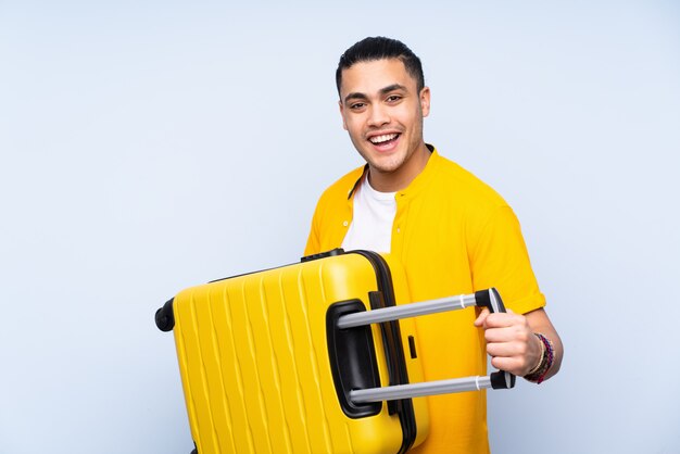 hombre guapo en azul en vacaciones con maleta de viaje