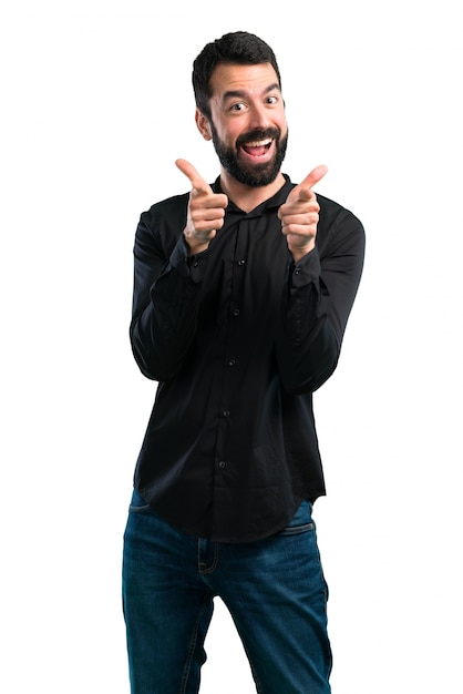 Hombre guapo con barba apuntando al frente sobre fondo blanco