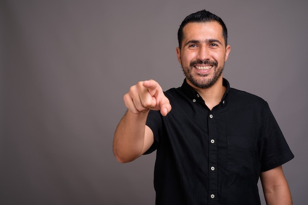 Hombre guapo con barba contra la pared gris