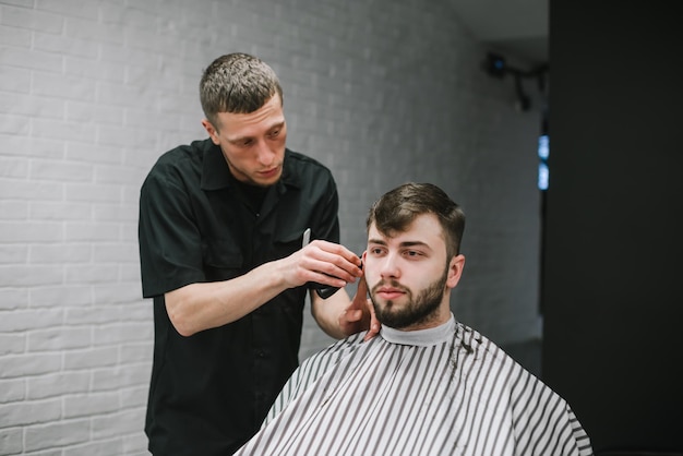 Hombre guapo con barba corta el pelo en peluquero profesional