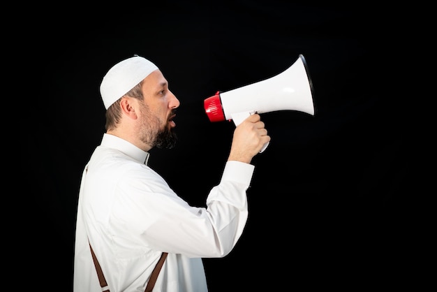 Hombre guapo con barba gritando por megáfono para hajj en mekkah