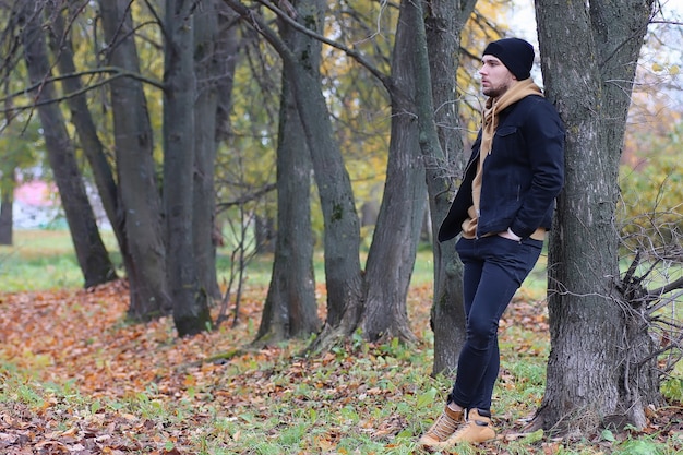 Hombre guapo con barba en el parque otoño posando en la cámara