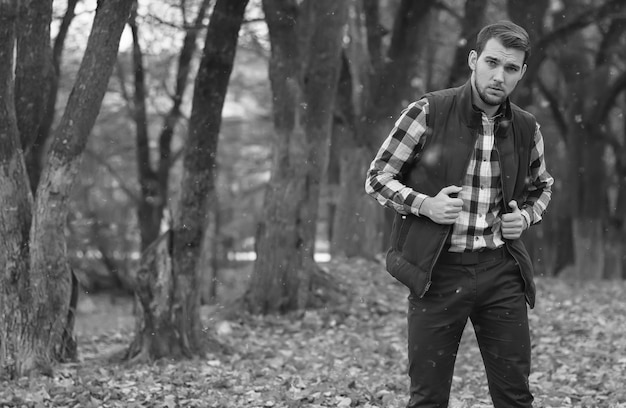 Hombre guapo con barba en el parque otoño posando en la cámara