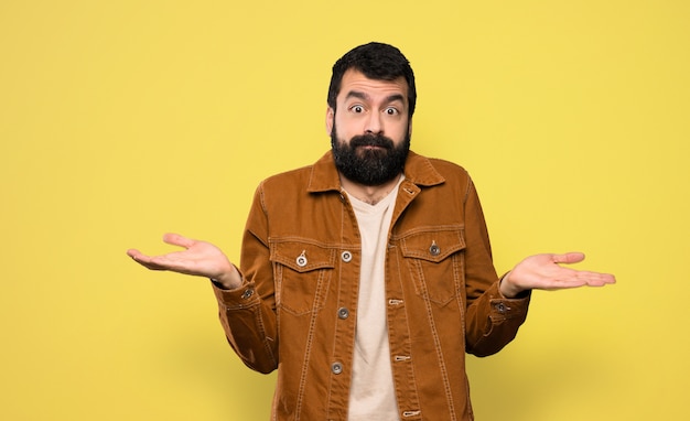 Foto hombre guapo con barba teniendo dudas mientras levanta las manos