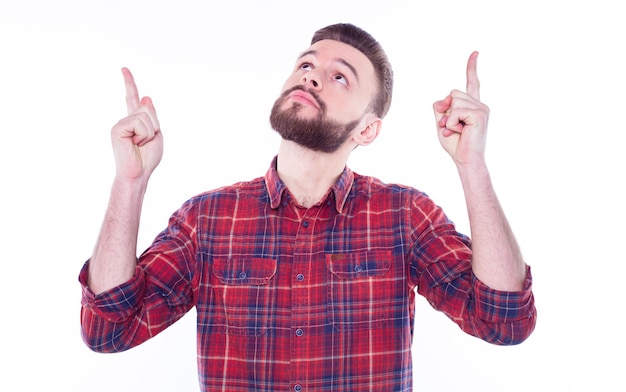 Un hombre guapo y barbudo, seguro de sí mismo, con un pantalones casual a cuadros, está posando aislado en un fondo blanco con espacio para copiar texto y publicidad