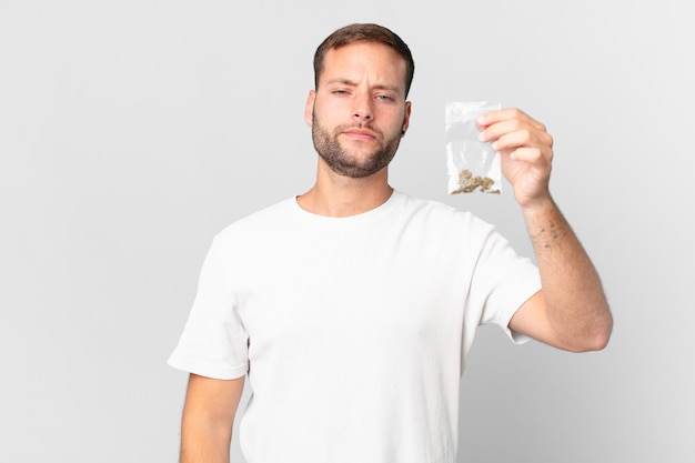 Hombre guapo con una bolsita de marihuana