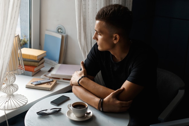 Hombre guapo con café relajándose en el restaurante