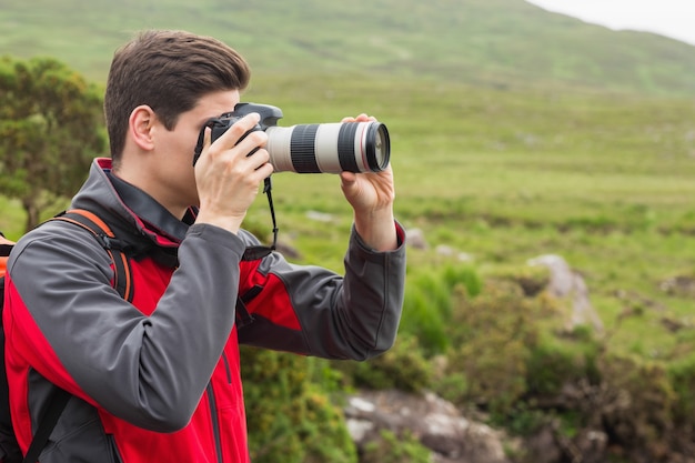 Hombre guapo en una caminata tomando una fotografía