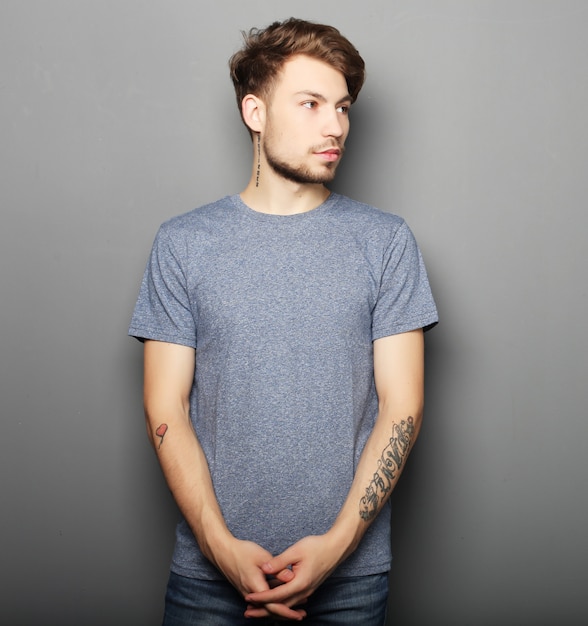 Hombre guapo en camisa gris en blanco