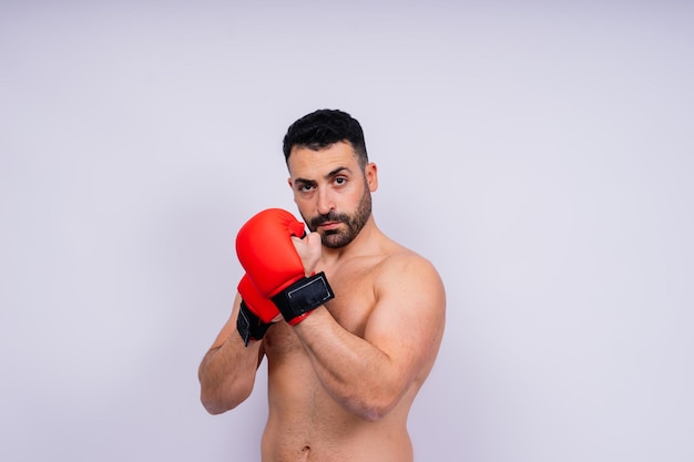 Hombre guapo caucásico joven aislado sobre fondo blanco con guantes de boxeo