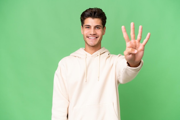 Hombre guapo caucásico joven sobre fondo aislado feliz y contando cuatro con los dedos