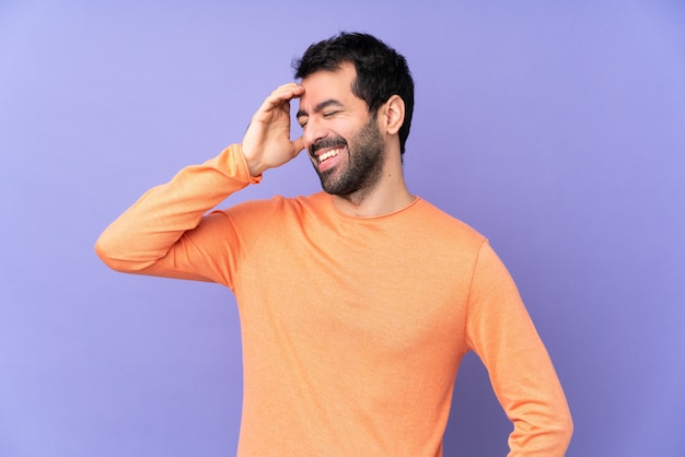 Hombre guapo caucásico sobre púrpura aislado sonriendo mucho