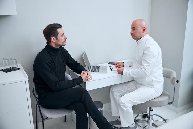 Hombre guapo durante la cita con el médico en el hospital