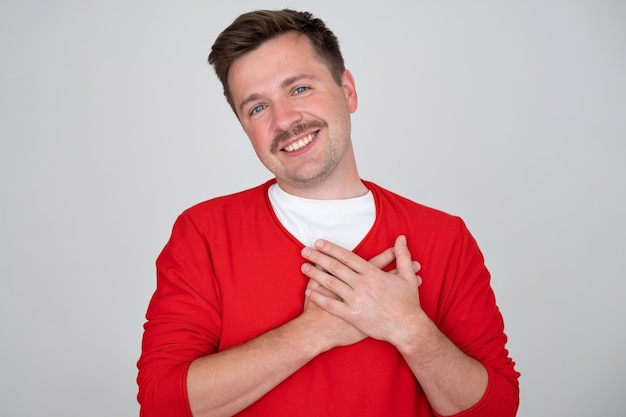 Hombre guapo complacido expresa su sentimiento positivo a las personas que lo rodean