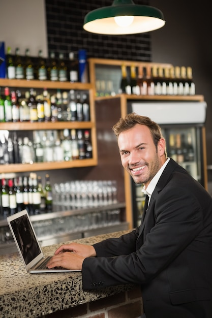 Hombre guapo con computadora portátil