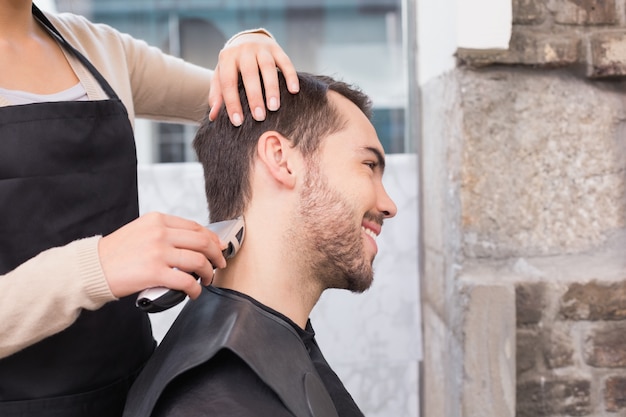 Hombre guapo cortándose el pelo