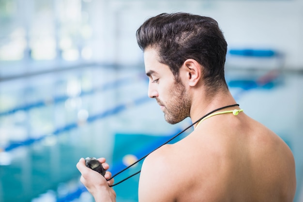 Hombre guapo con cronómetro en la piscina