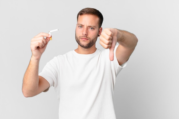 Foto hombre guapo dejar de fumar con un puro roto