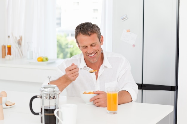 Hombre guapo desayunando en la cocina