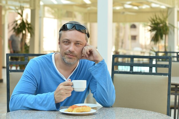 Hombre guapo y desayuno en la mesa