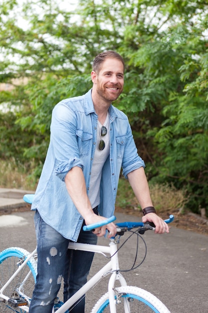 Hombre guapo con disfrutar con su bicicleta en el parque