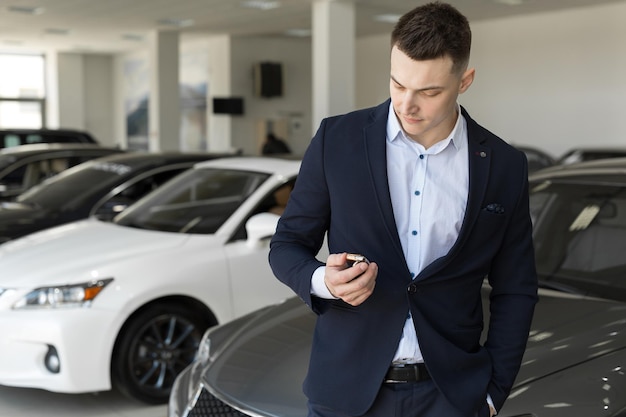 Hombre guapo eligiendo un coche en una sala de exposiciones