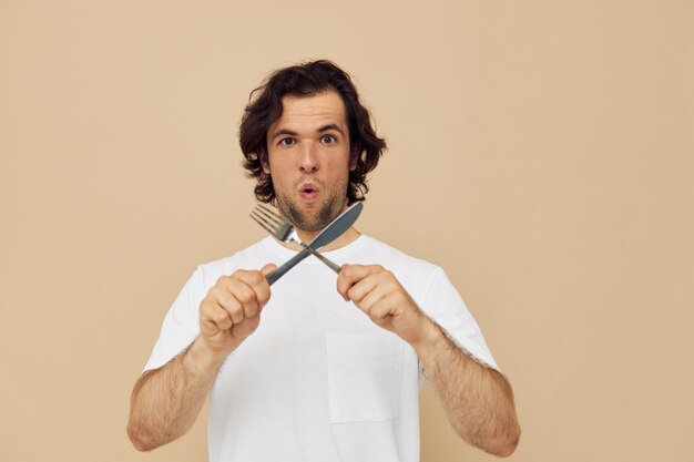Hombre guapo emociones cuchillo y tenedor utensilios de cocina fondo aislado