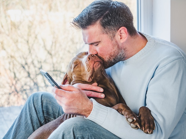 Hombre guapo y un encantador cachorro. De cerca