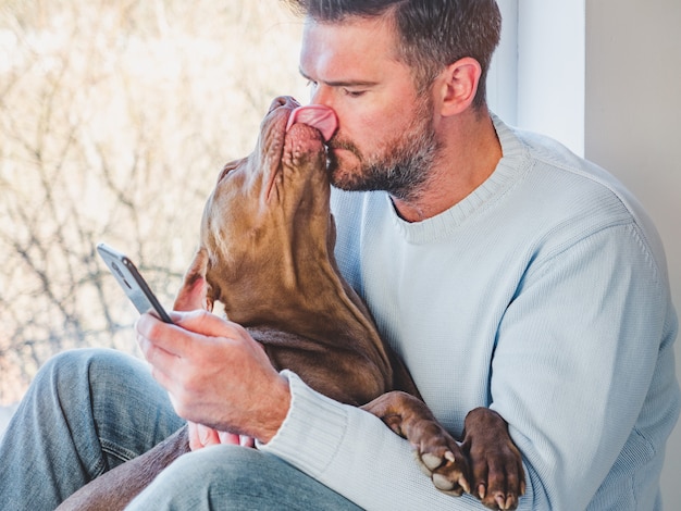 Hombre guapo y un encantador cachorro. De cerca