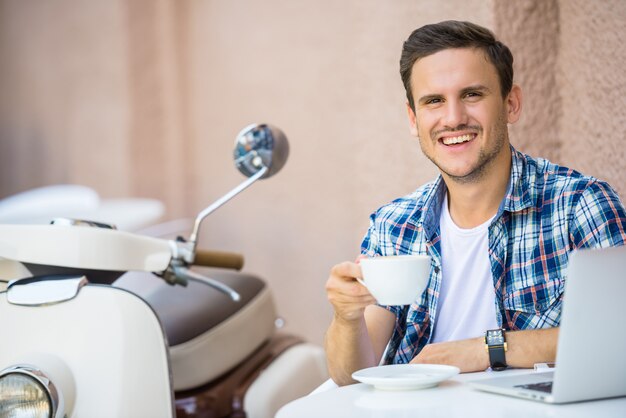 Hombre guapo es relajante en café y tomando café.